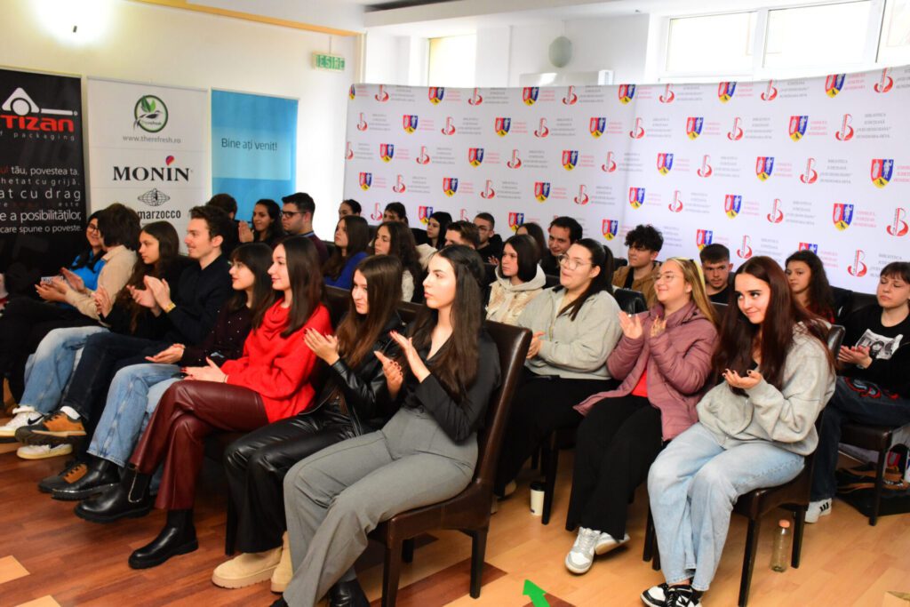 Tinerii participanți la concursul de cultură generală, aplaudând și interacționând în timpul evenimentului organizat de Biblioteca Județeană „Ovid Densusianu” Hunedoara - Deva.